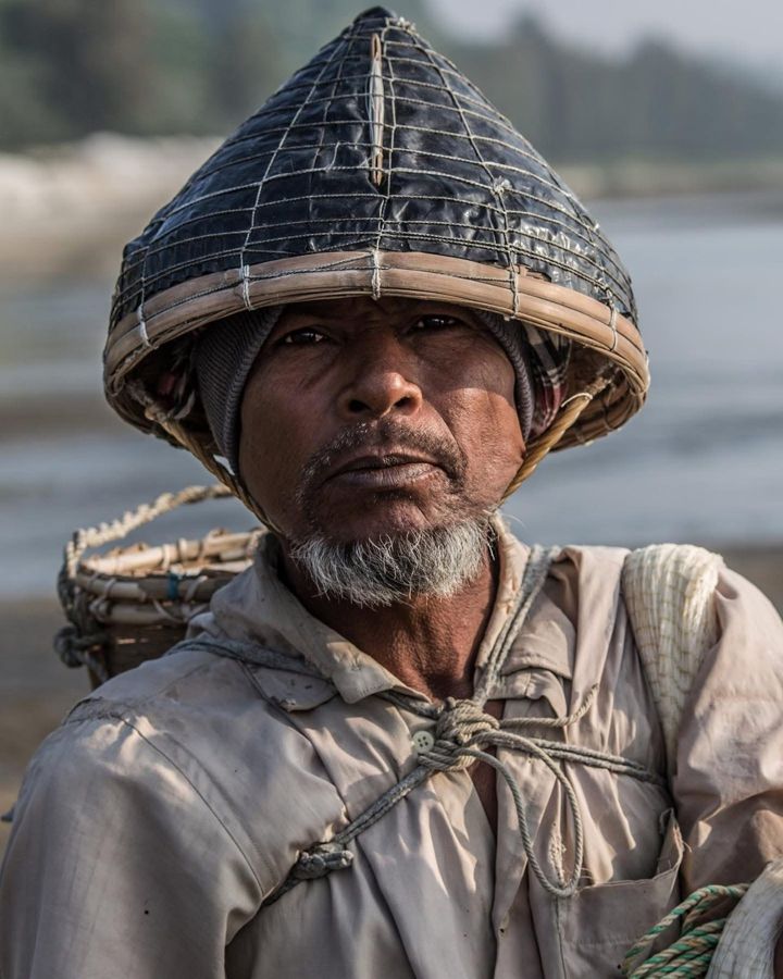 Shivula, Cox's Bazar, Bangladesh: Shivula, a shallow-water fisherman, in a woven conical hat with a basket on his back. Photograph by Marcus Vallance.