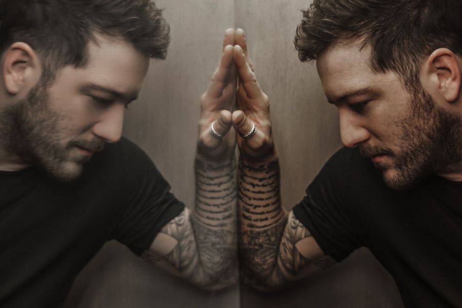 Matt Cardle, Manchester, UK: double portrait in profile, tattooed hands pressed together. Photograph by Marcus Vallance.