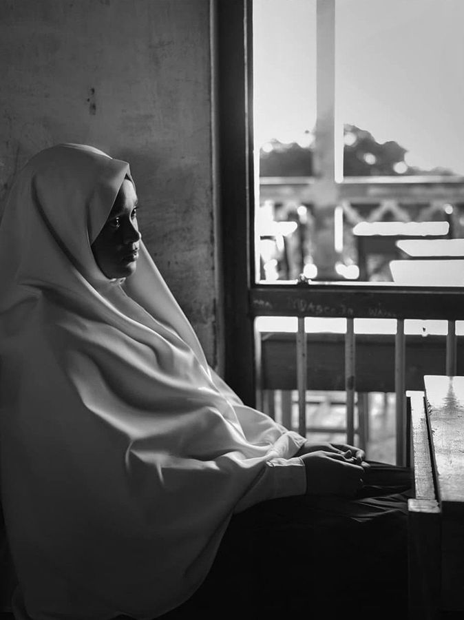 Portrait of a Girl, Zanzibar, Tanzania: black and white profile of a woman in a headscarf seated by a window. Photograph by Marcus Vallance.
